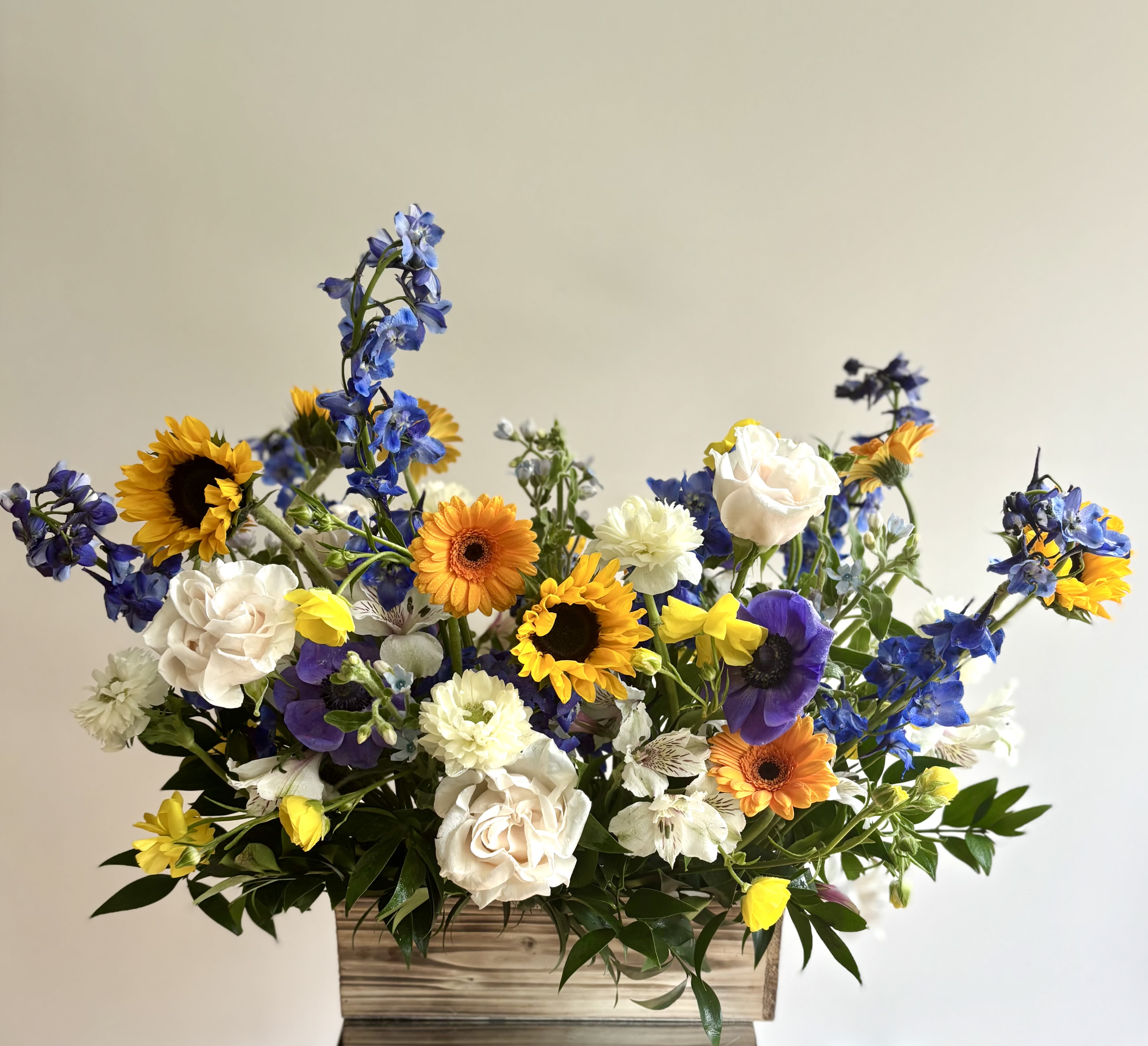 Provence - Wonderful seasonal flower box with fresh cut flowers in a mix of yellow, white, and blue color tones. Our designer carefully selects flowers to create this French styled arrangement - usually with roses, delphinium, sunflowers, ranunculus, gerbers and other seasonal flowers.