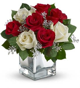 Snowy Night Bouquet - The perfect Christmas hostess gift, this exciting bouquet of red and white roses in a dazzling mirrored cube is guaranteed to make spirits brighter. Simple, stylish, affordable ¬- better order one for yourself as well.  The delightful holiday bouquet features red roses and white roses accented with assorted greenery.  Approximately 11" W x 10 3/4" H  Orientation: All-Around  As Shown : T407-2A Deluxe : T407-2B Premium : T407-2C