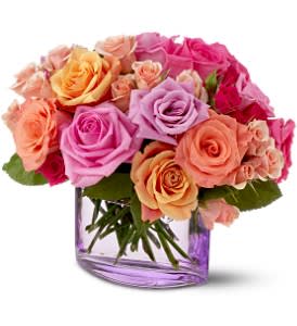 Bouquet of pink, peach, and lavender roses in a purple glass vase