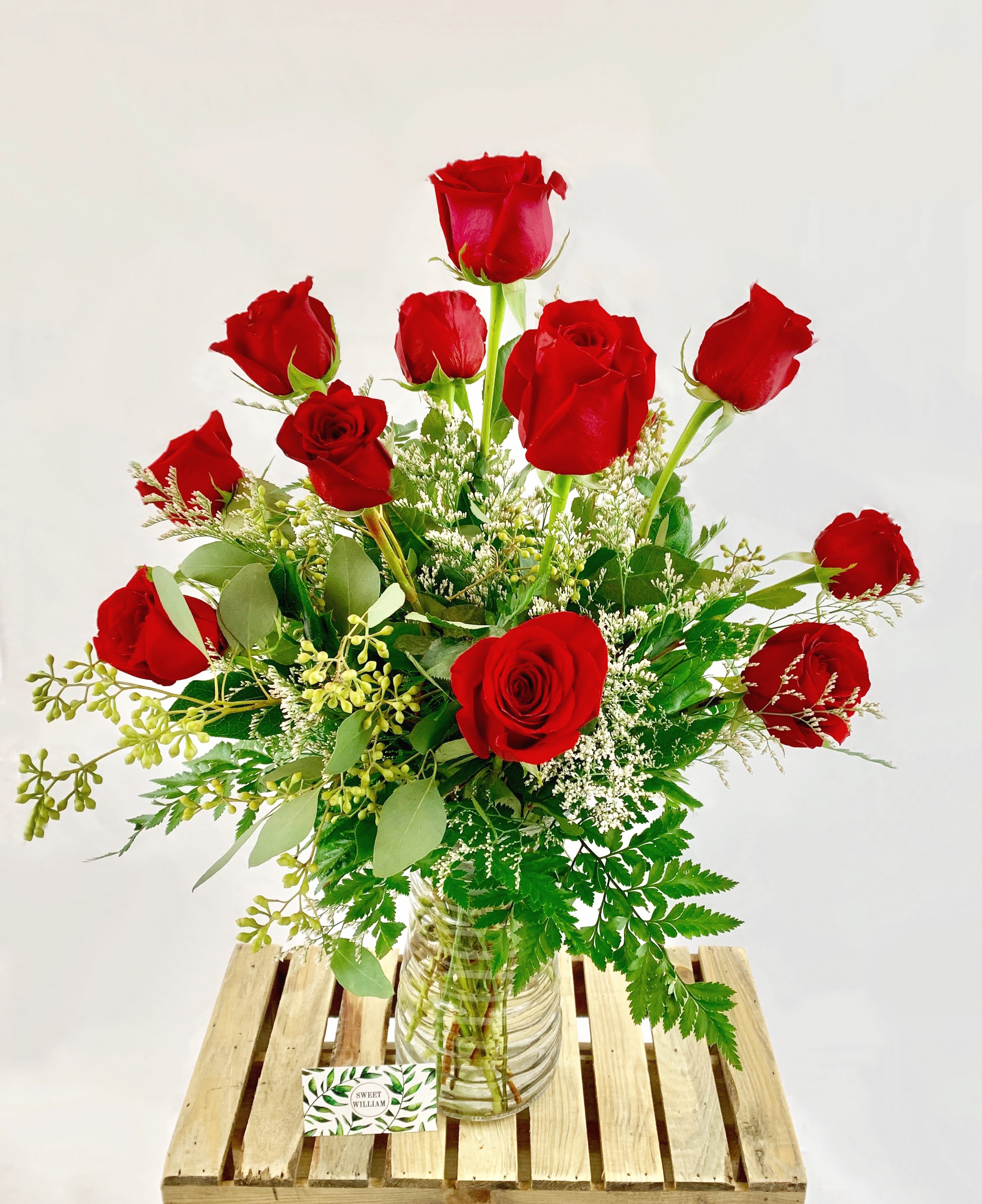 Red roses arranged in a clear glass vase