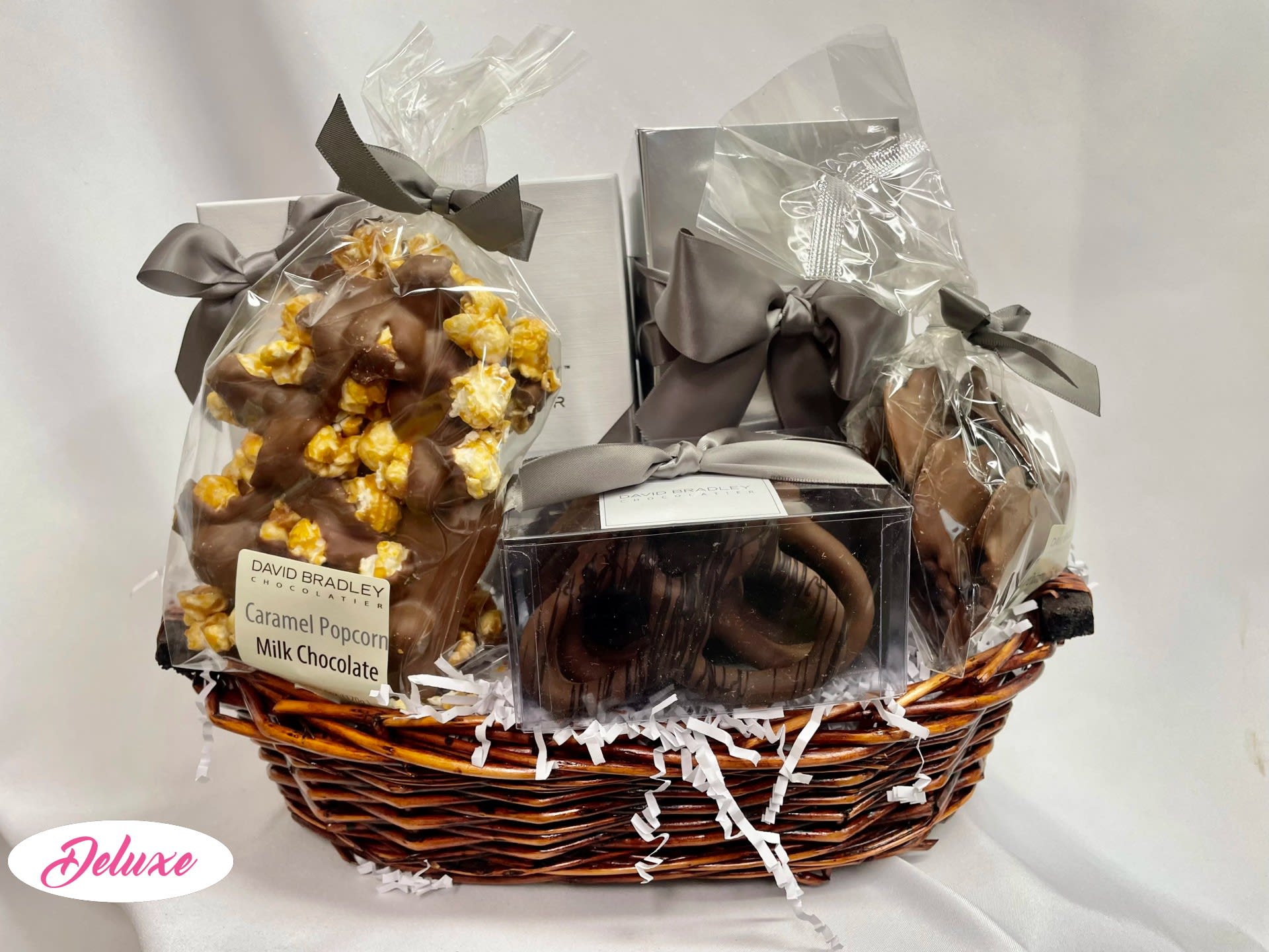 Gift basket with wrapped chocolates and caramel popcorn in a wicker basket