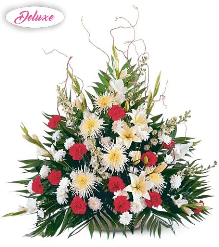 Large red, white, and yellow floral arrangement with tropical leaves