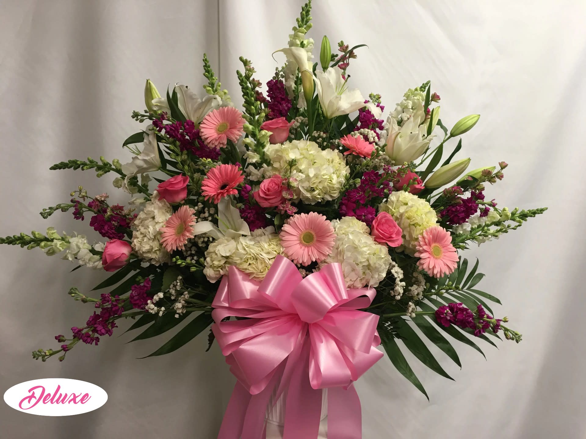 Pink and white mixed flower arrangement with a large pink bow