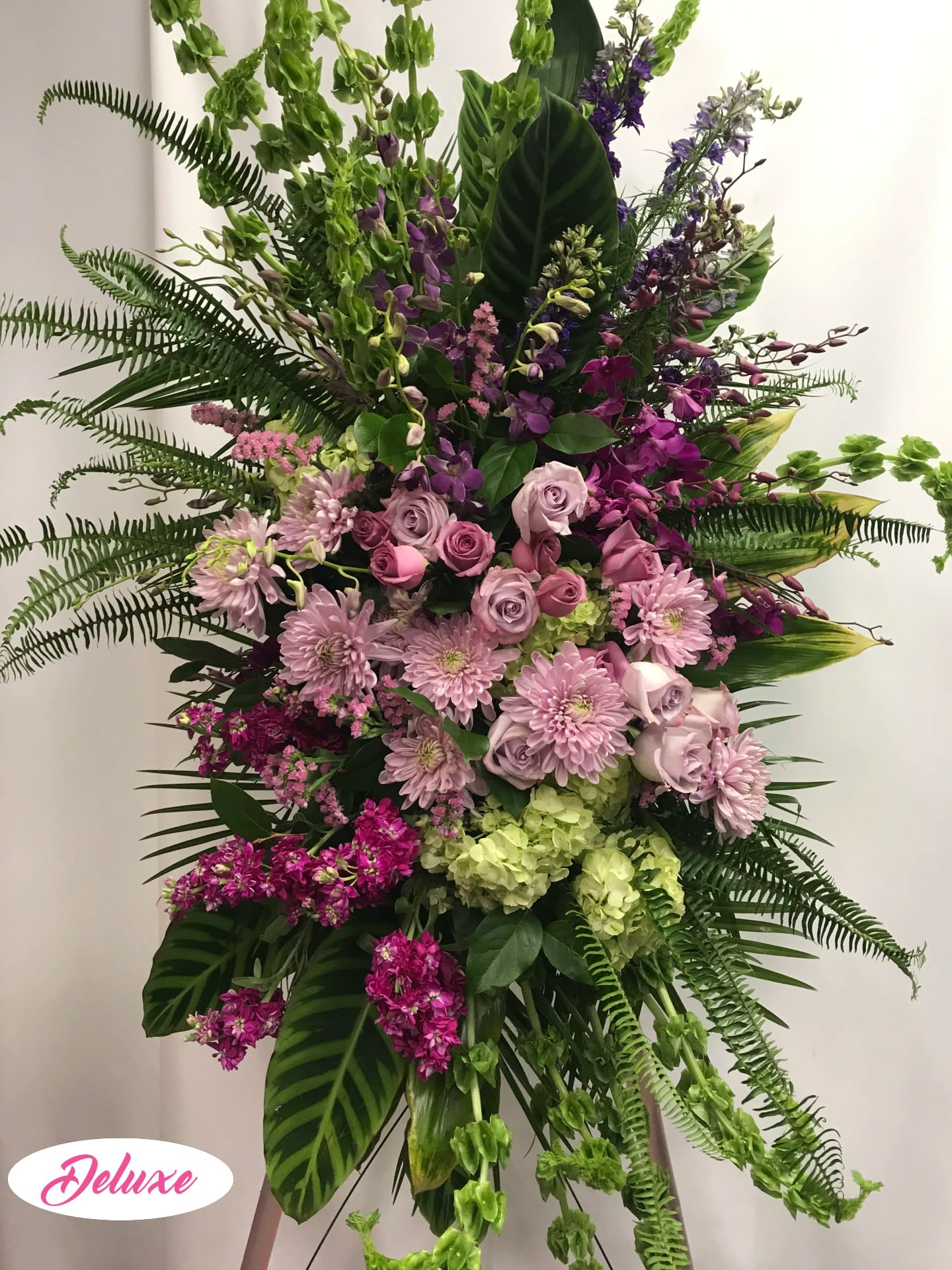 Large standing floral spray with pink roses and purple blooms