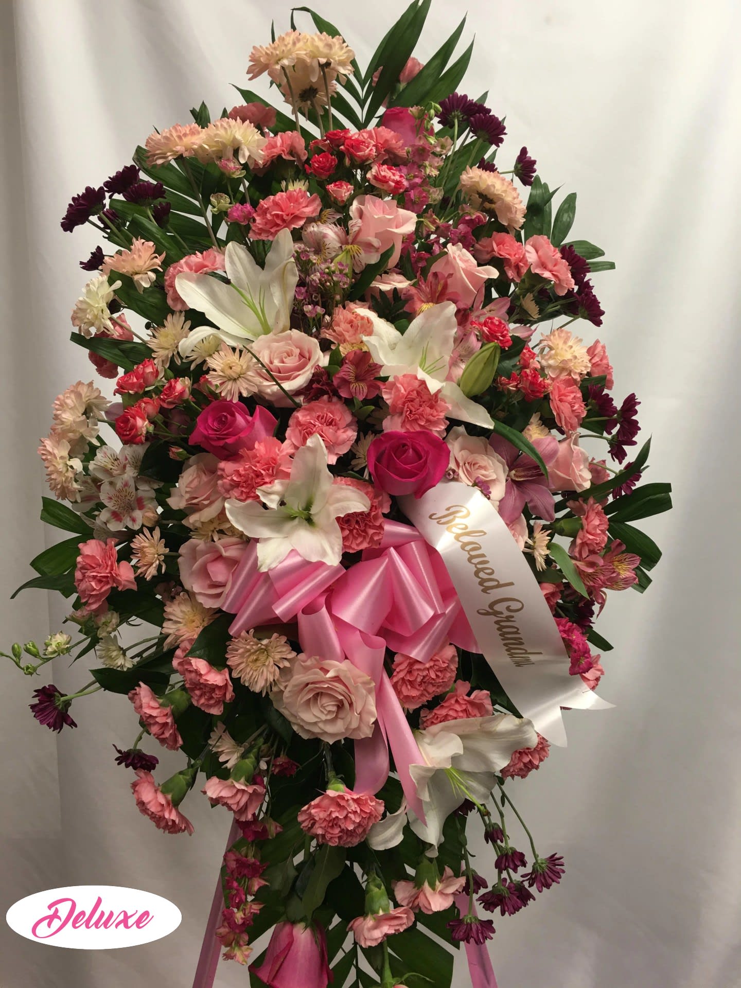 Large pink and white standing floral spray with a ribbon