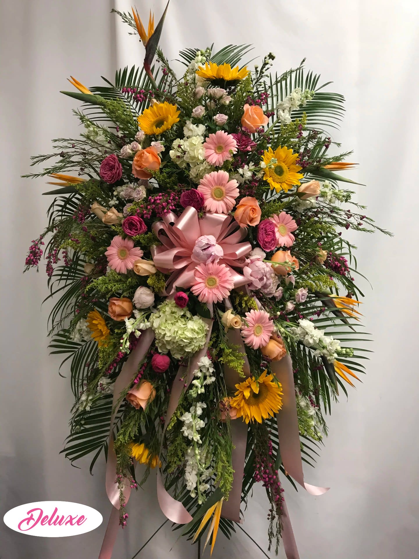 Large standing floral spray with pink and yellow flowers and ribbon