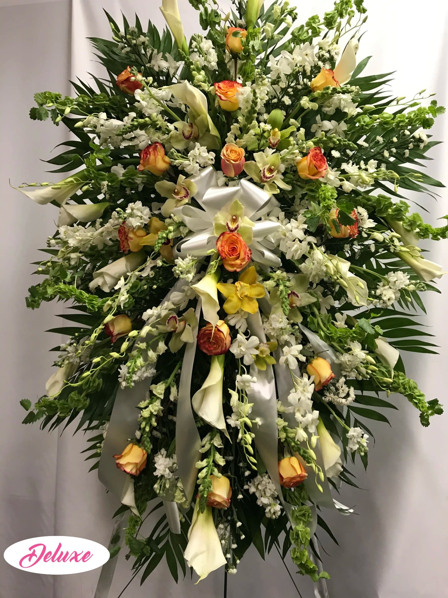 Large standing floral spray with white lilies, roses, and orchids