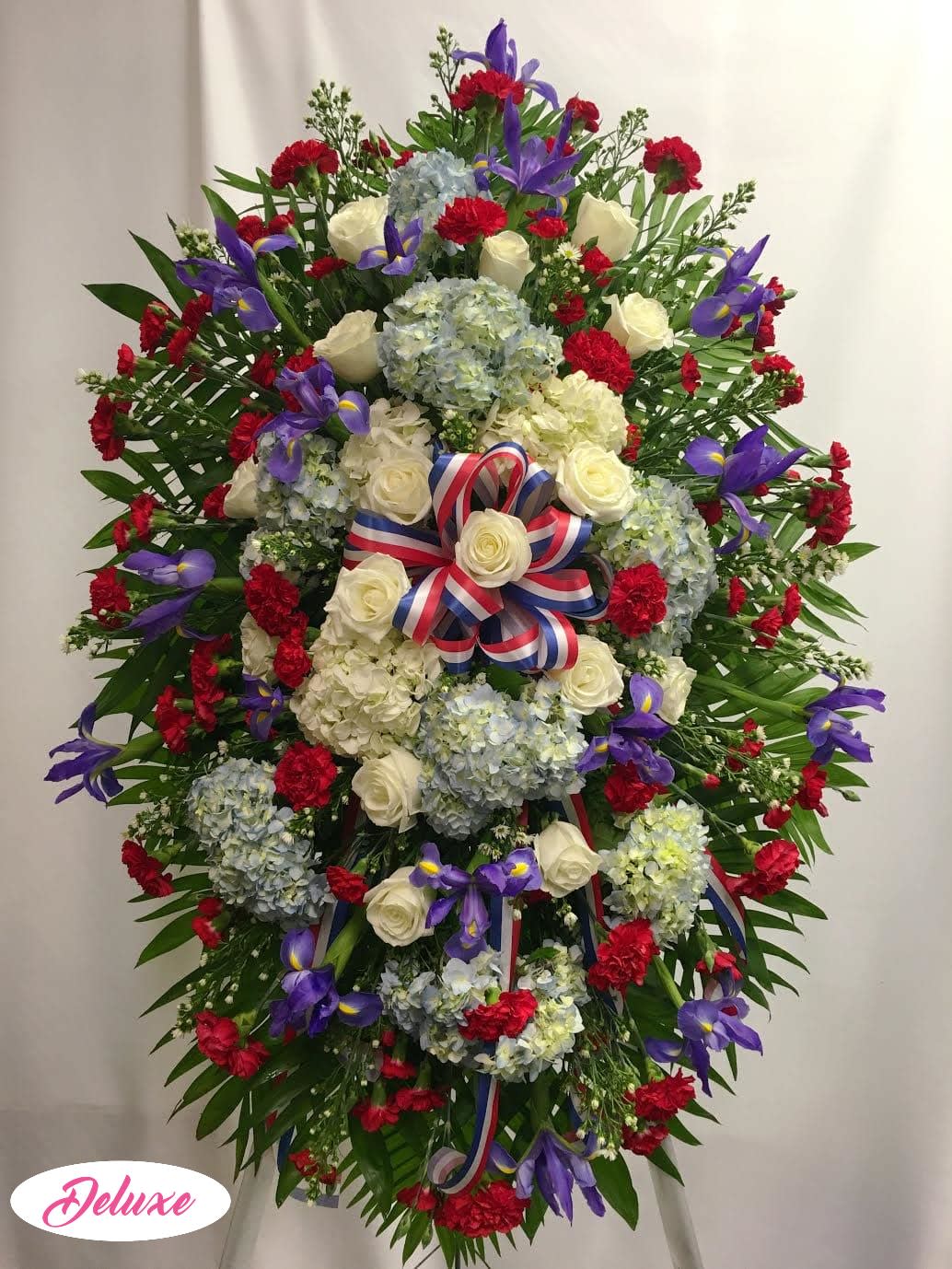 Large standing floral wreath with roses, hydrangeas, and purple irises