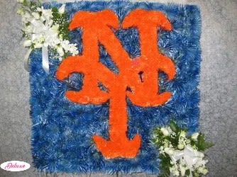 Blue floral tribute with orange monogram and white flower clusters