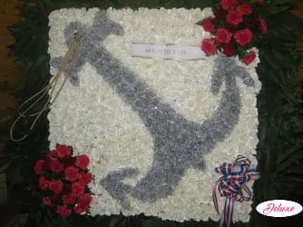 White floral funeral tribute with a gray dove design and red rose clusters