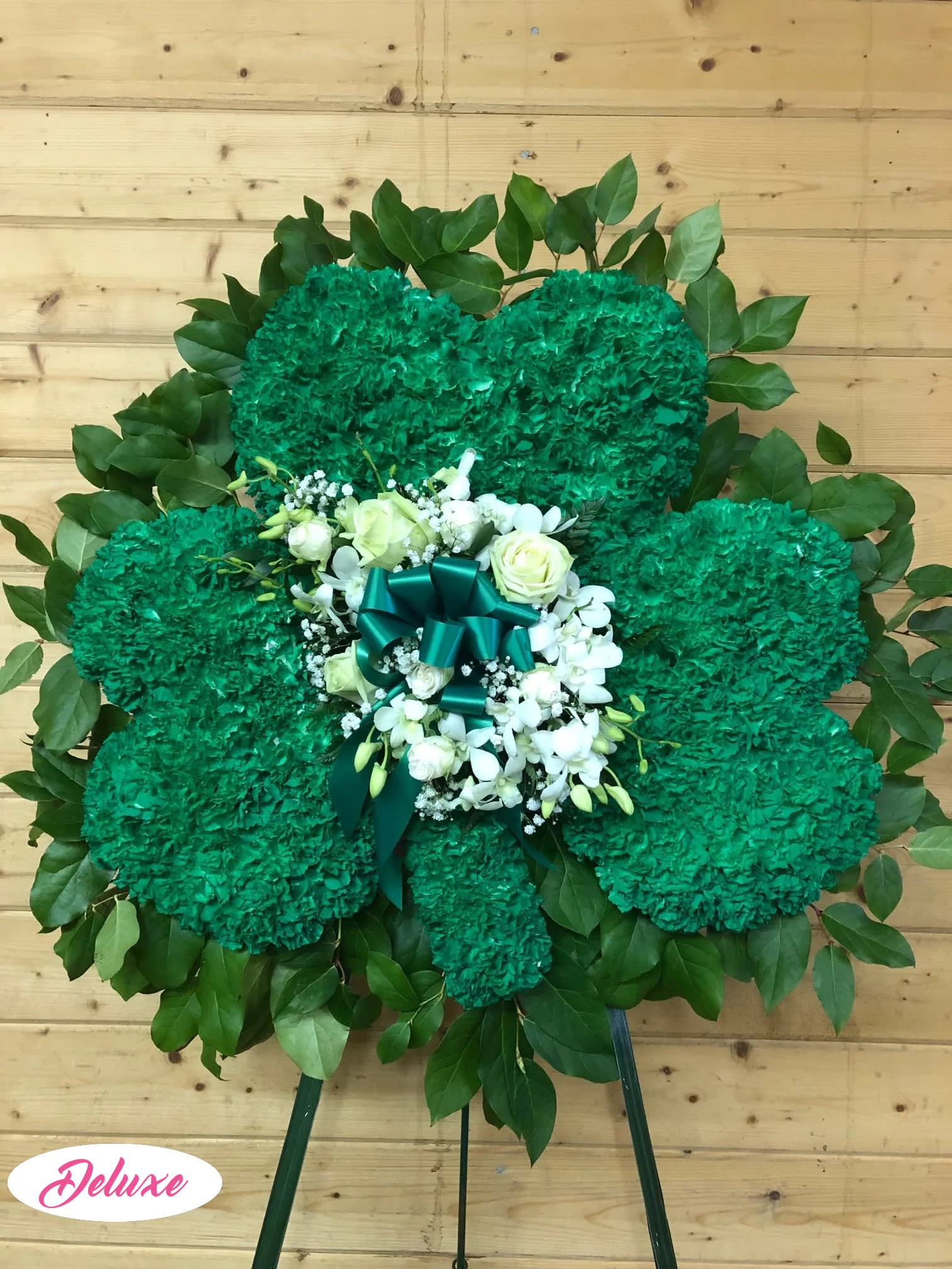 Green floral standing spray with white roses and ribbon