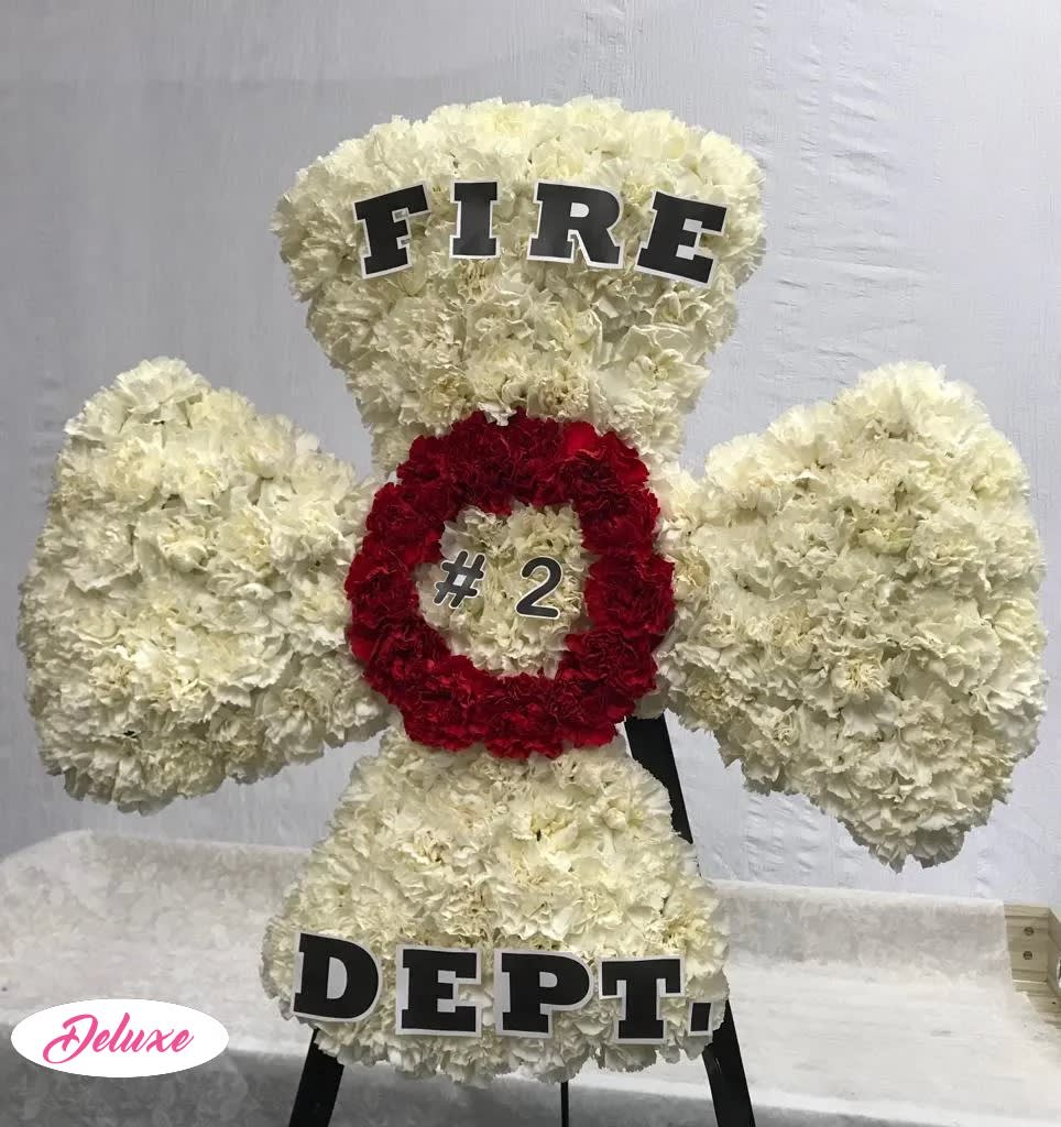 White floral standing display shaped like a fire department emblem with red center