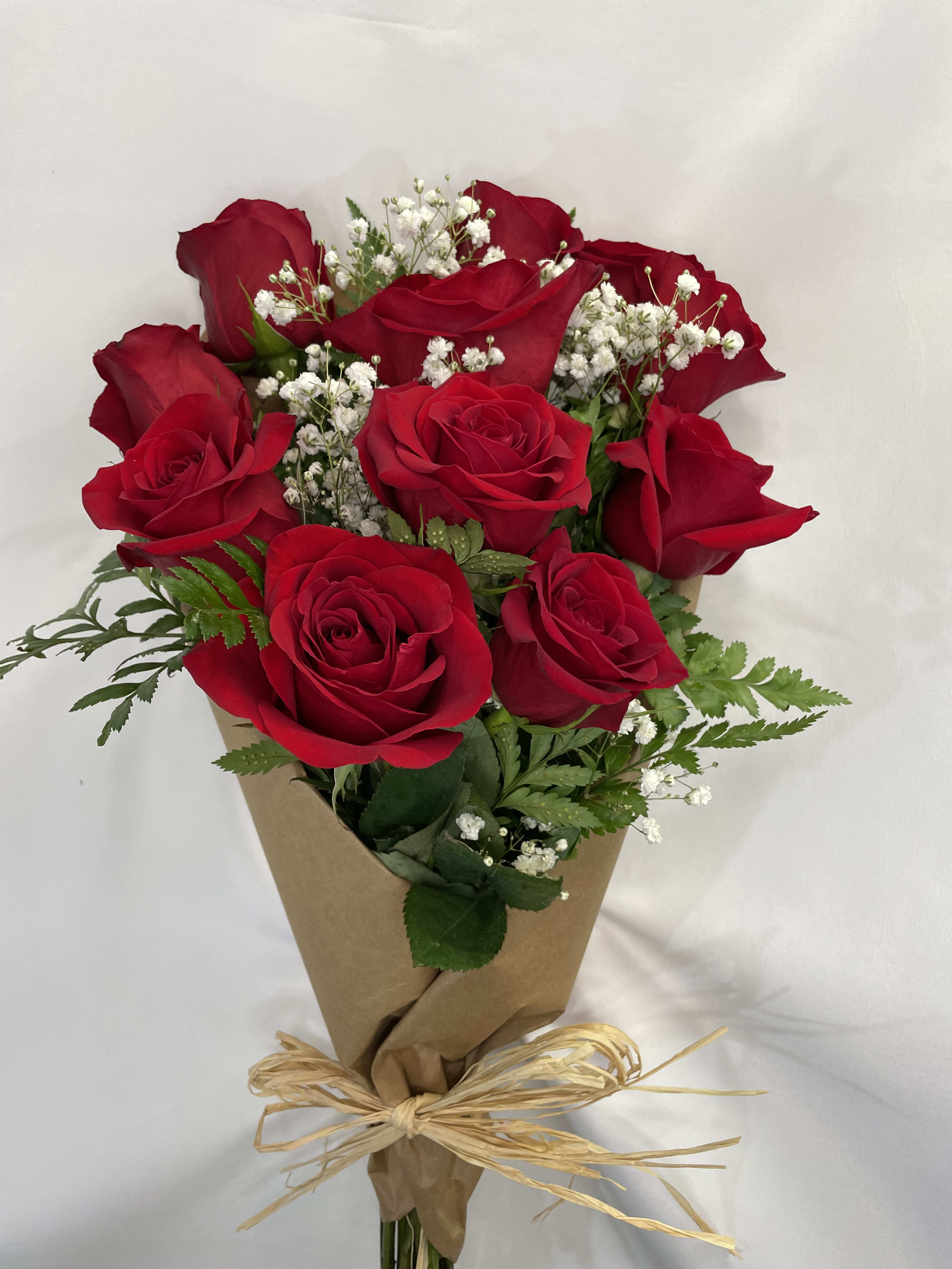 Bouquet of red roses with baby's breath wrapped in brown paper