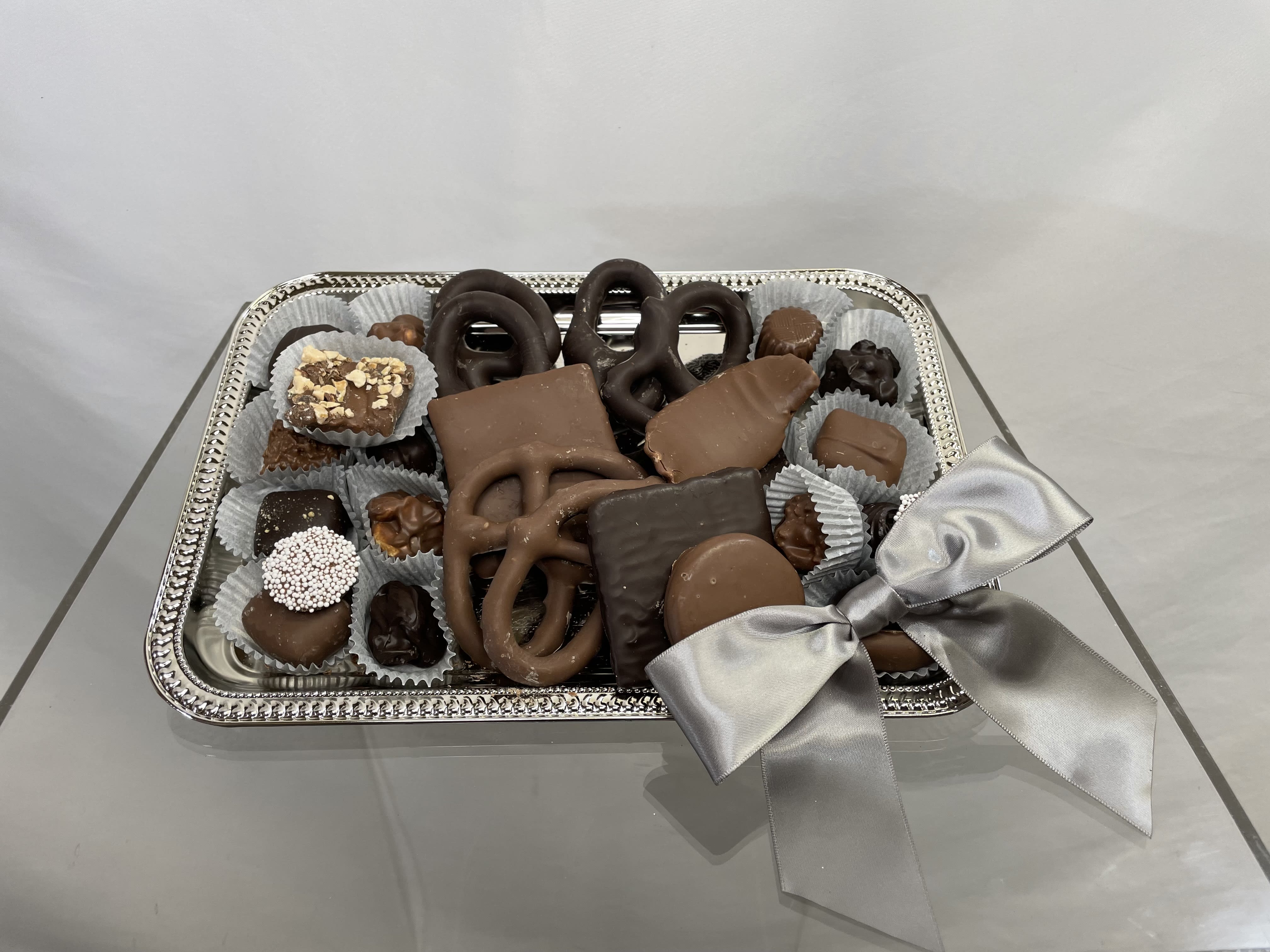 Tray of assorted chocolates tied with a silver ribbon