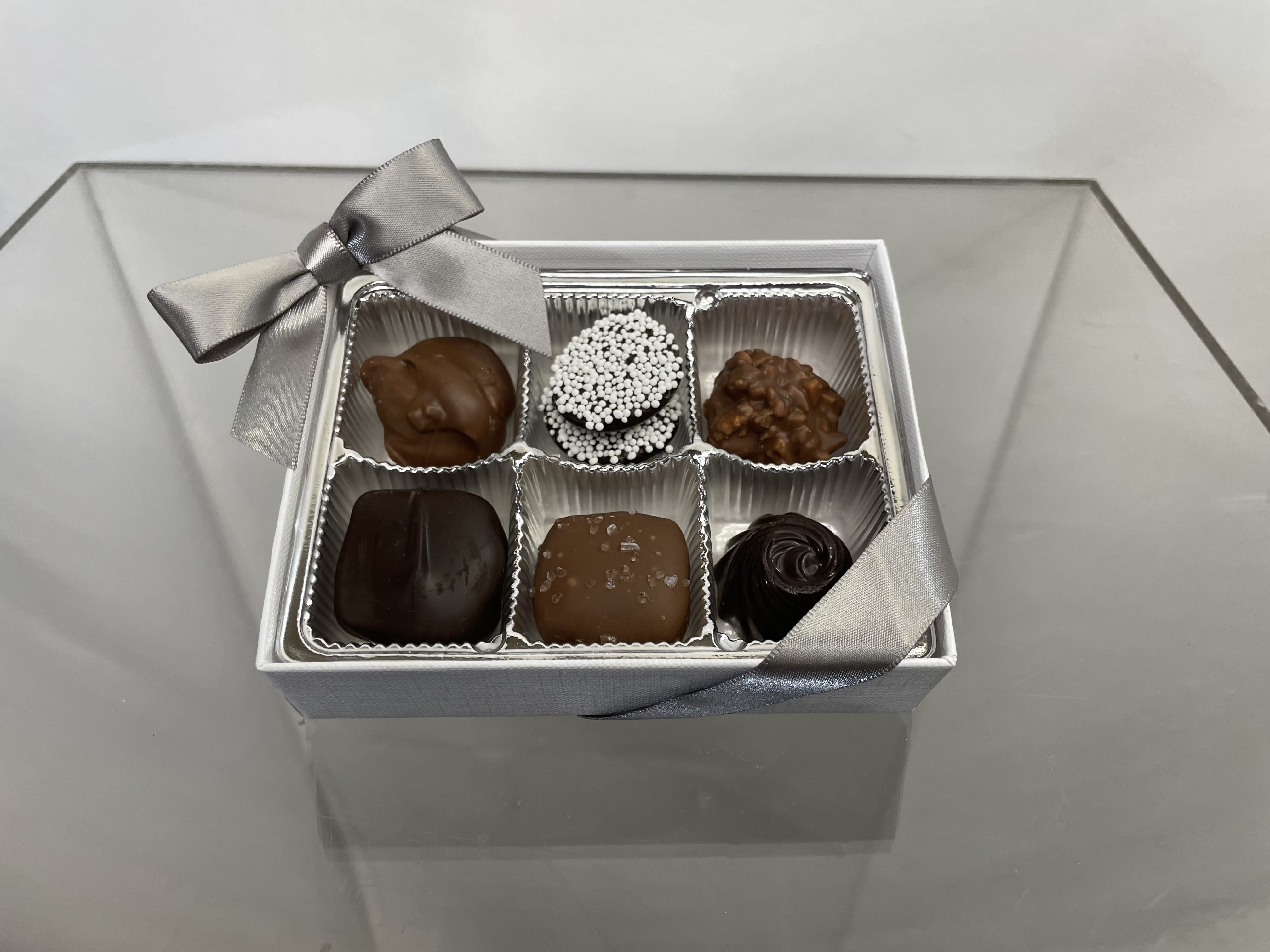 Box of assorted chocolates with a silver ribbon bow