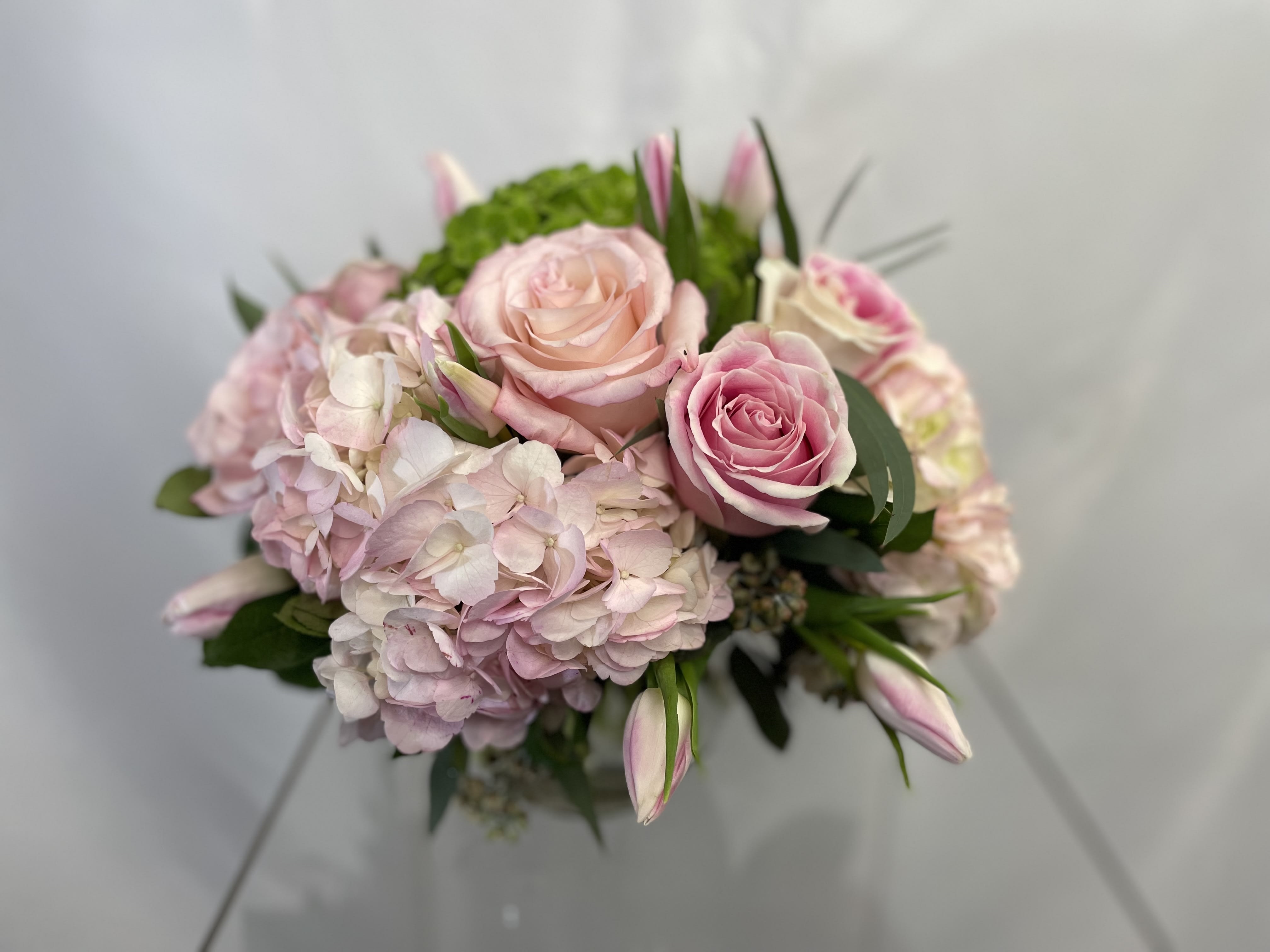 Pink roses and pale hydrangeas in a hand-tied bouquet