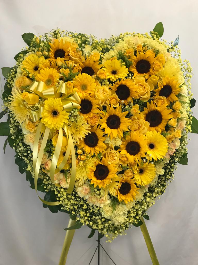 Heart-shaped yellow floral standing spray with sunflowers and roses