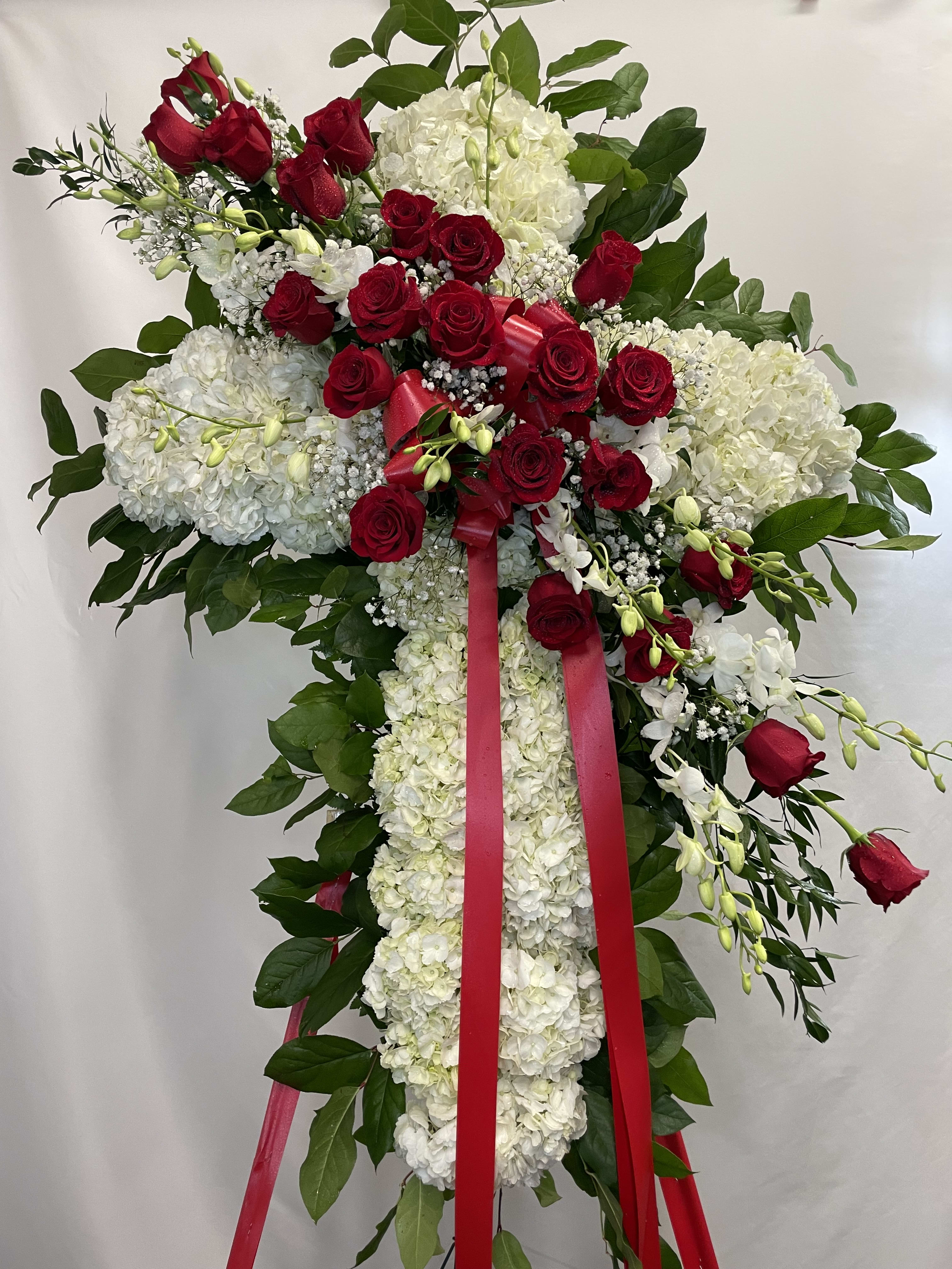 Standing floral spray with red roses and white hydrangeas on a ribboned easel