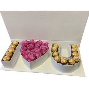 Gift box with pink roses and Ferrero Rocher chocolates arranged as letters.