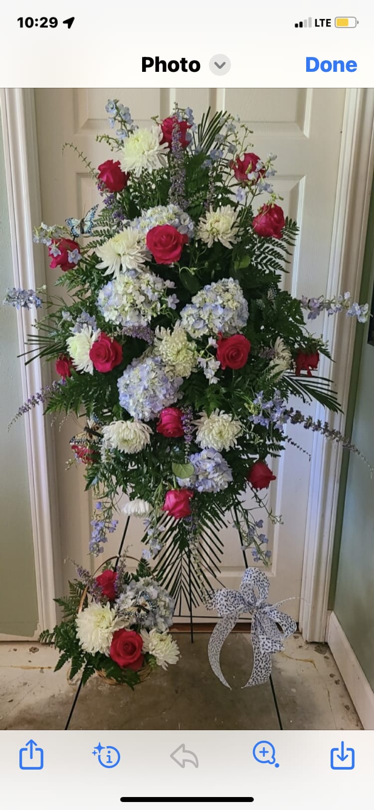 Tall floral standing spray with pink roses, white blooms, and blue hydrangeas