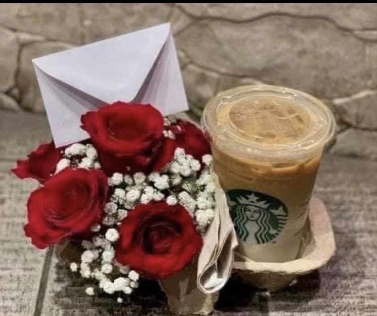 Small bouquet of red roses with baby's breath beside an iced Starbucks drink