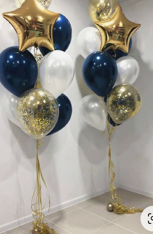 Two balloon bouquets with gold star balloons, navy and white balloons, and confetti balloons
