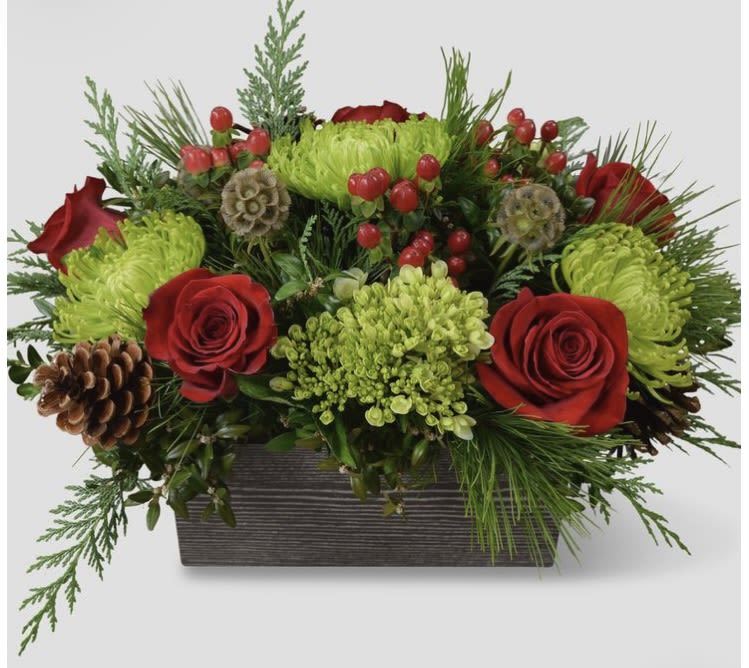 Red roses and green chrysanthemums in a rectangular planter with pinecones