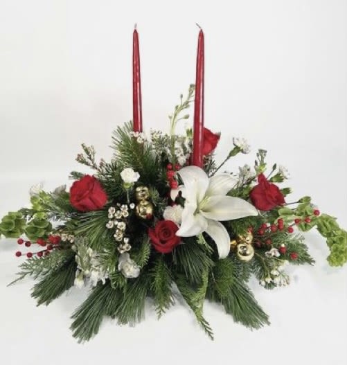 Holiday floral centerpiece with red candles, white lily, and red roses