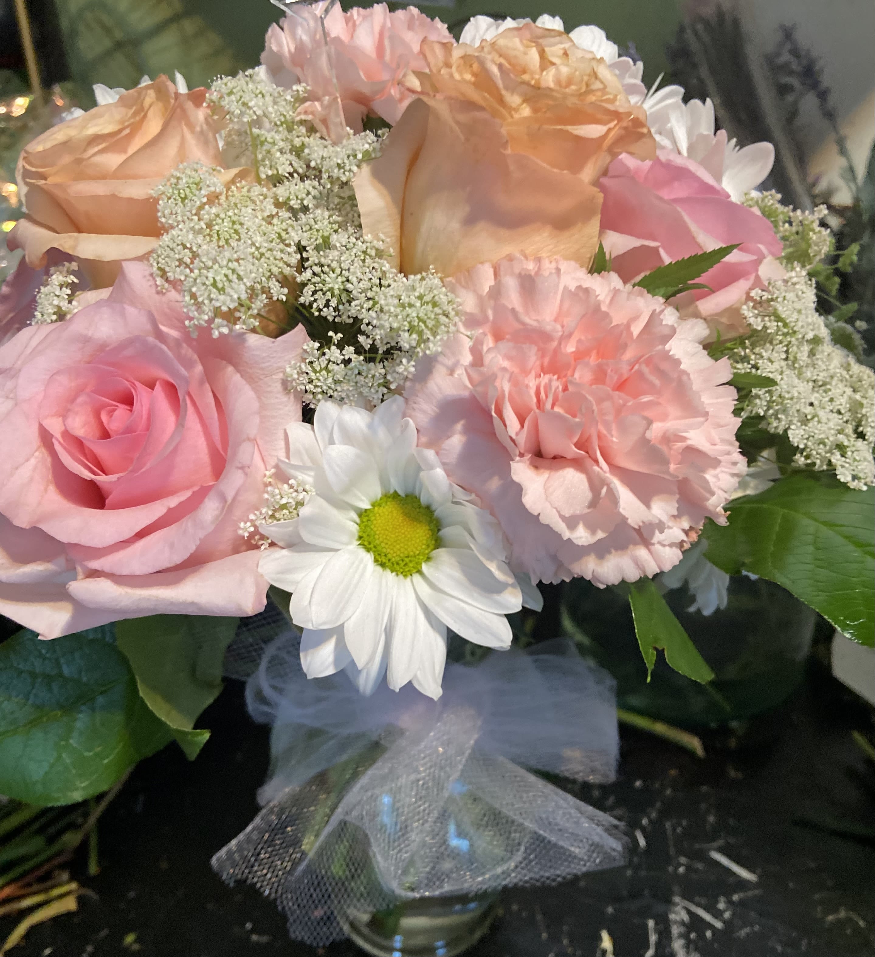 Bouquet of pink and peach roses with white daisies and carnations