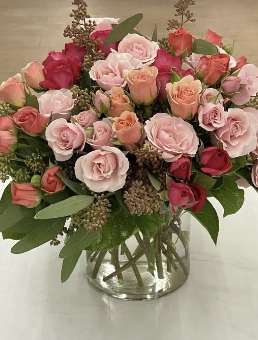 Bouquet of pink and peach roses in a clear glass vase