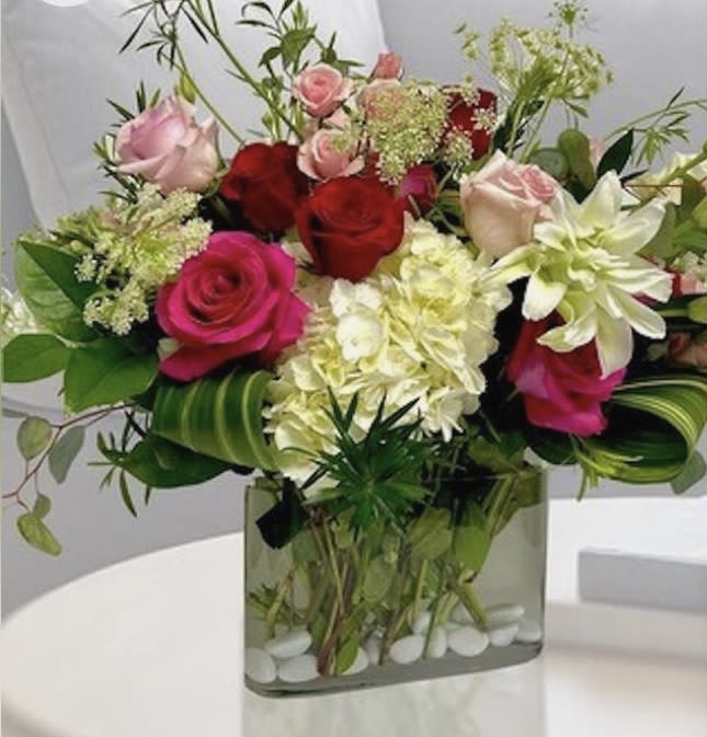 Mixed roses and white blooms in a square glass vase