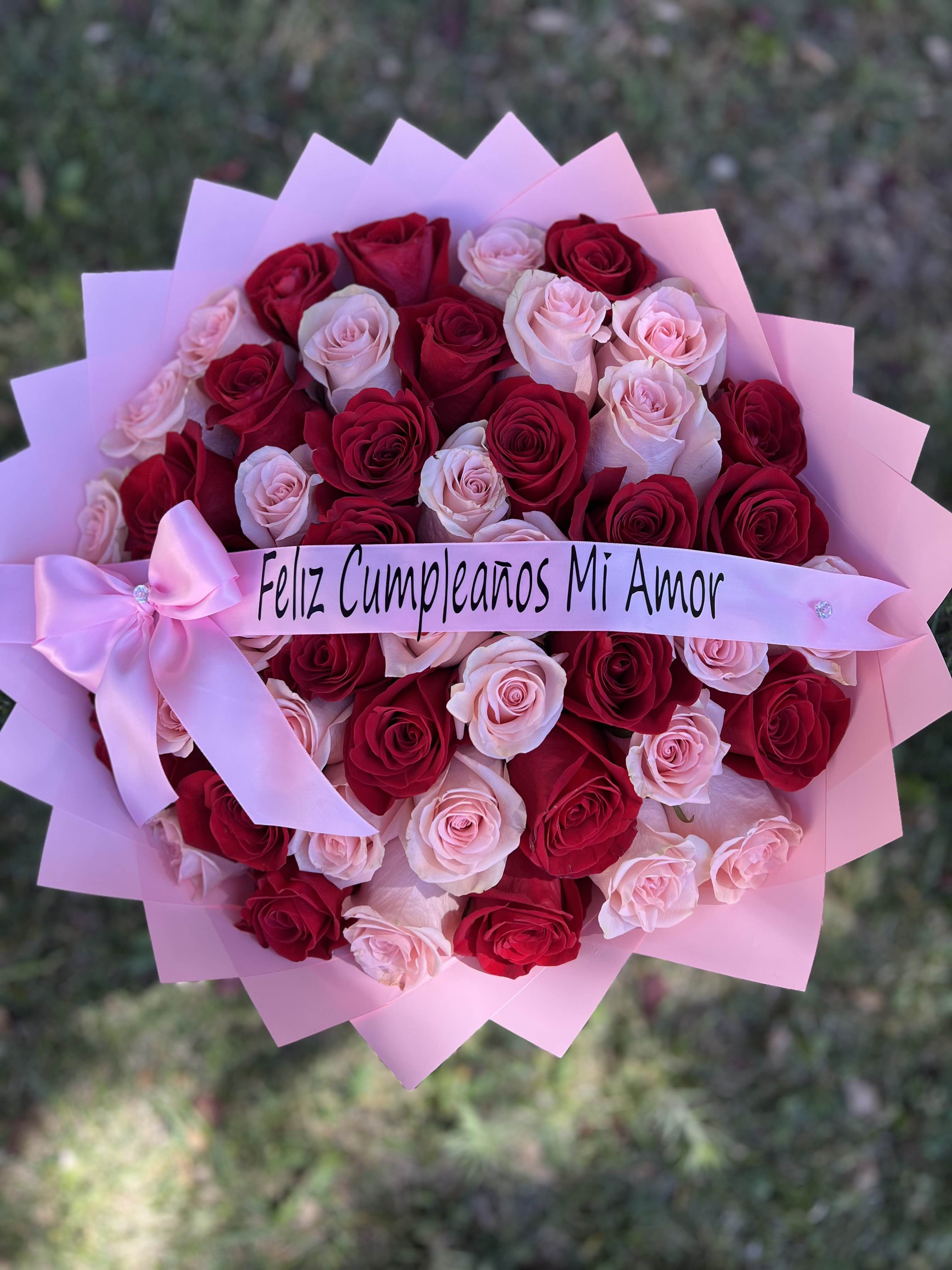 Rouge &amp; Blush - This stunning Rouge &amp; Blush arrangement features a lush, dense collection of premium red and soft pink roses, meticulously hand-tied to create a striking romantic contrast. Wrapped in signature pleated pink florist paper that frames the blooms like a crown, the bouquet is finished with a personalized satin ribbon and a matching decorative bow. Whether celebrating a birthday or a milestone, the Rouge &amp; Blush offers a timeless blend of passion and elegance, making it the ultimate luxury statement for someone special.