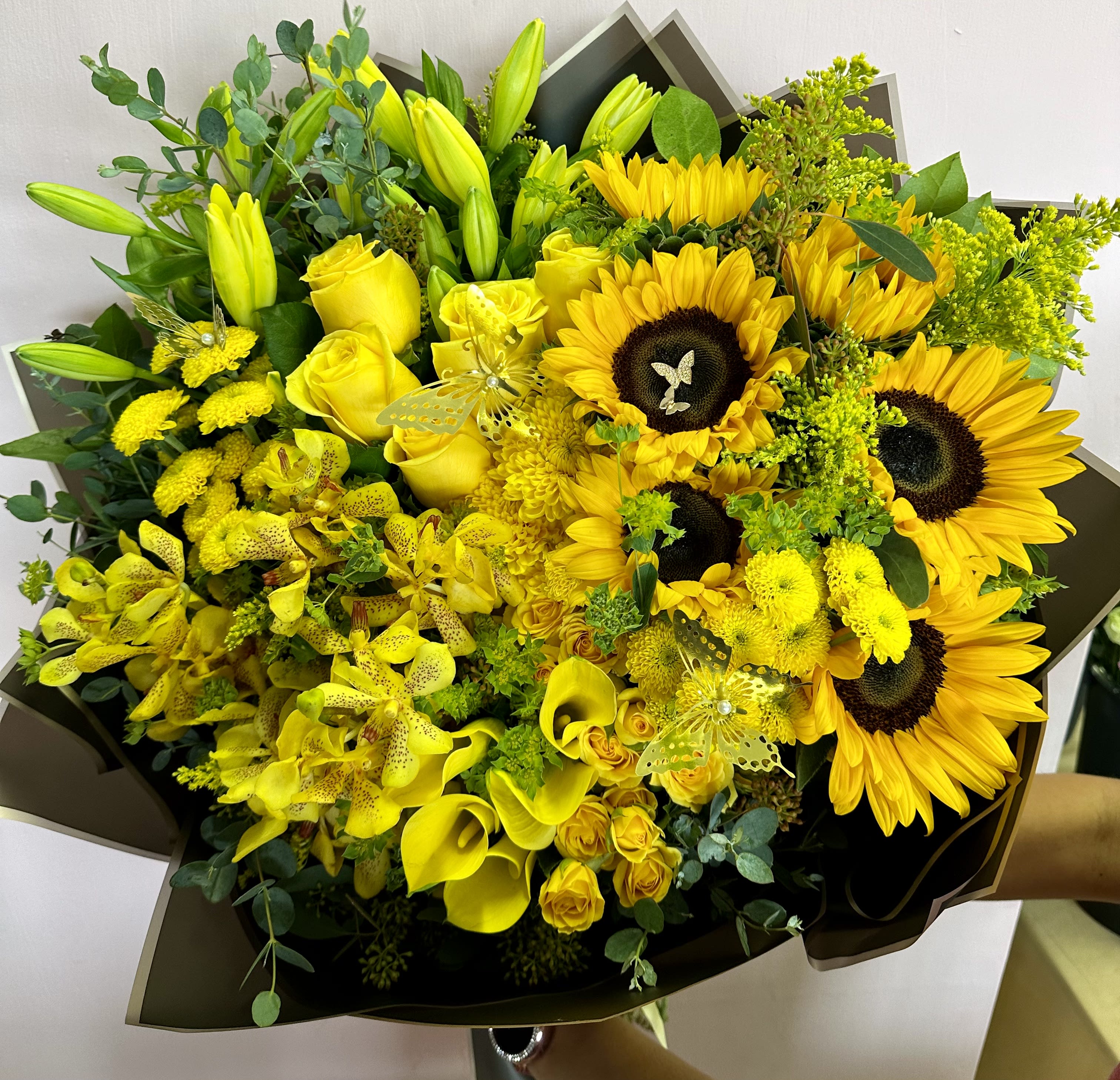Yellow bouquet with sunflowers, roses, lilies, and orchids