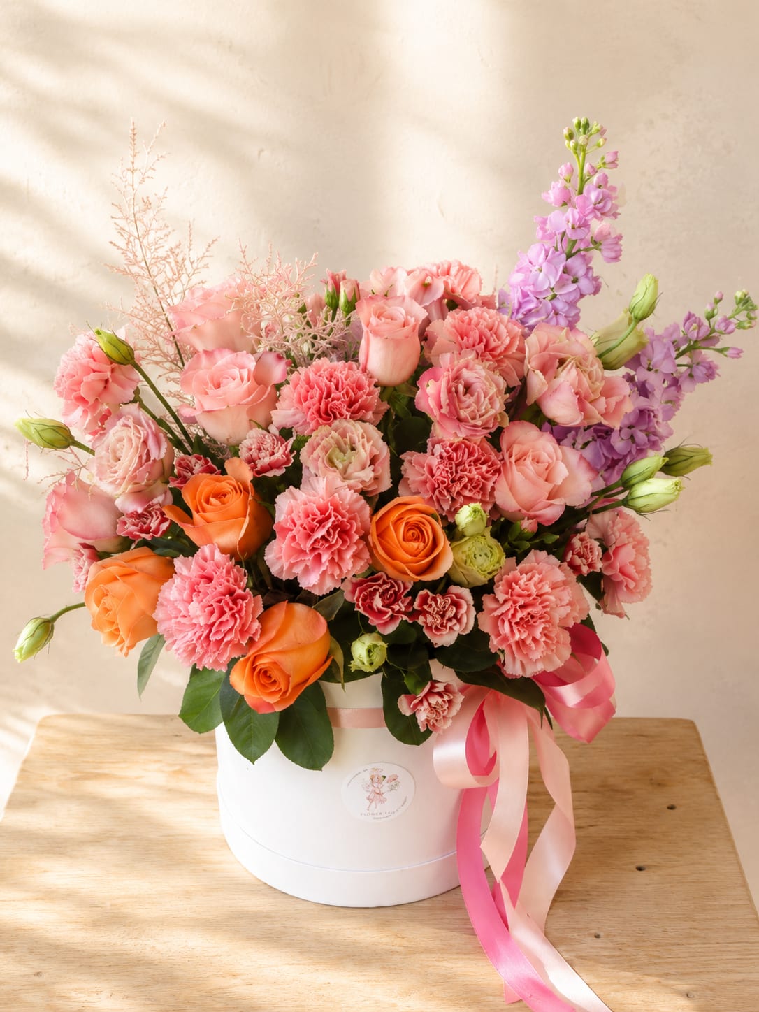 Aurora’s Blush – Blush &amp; Peach Flower Hat Box - Inspired by Aurora, the Roman goddess of the dawn, Aurora’s Blush captures the soft beauty of the first morning light in an elegant garden-inspired hat box arrangement.  Handcrafted with premium roses, spray roses, carnations, lisianthus, fragrant stock, and fresh seasonal blooms, this luxurious design features a romantic palette of blush pink, peach, and lavender tones. Flowing satin ribbons and an elegant keepsake hat box complete a timeless presentation that’s as beautiful as the flowers themselves.  Whether you’re celebrating a birthday, anniversary, welcoming a new baby, expressing gratitude, or simply brightening someone’s day, Aurora’s Blush delivers warmth, elegance, and joy with every bloom.  Each arrangement is handcrafted by Flower Fairy using the freshest flowers available. While occasional substitutions may be necessary due to seasonal availability, we always preserve the overall style, color palette, and premium quality of every design.  Features  * Premium roses and spray roses * Carnations, lisianthus, fragrant stock, and seasonal blooms * Elegant keepsake hat box * Romantic blush, peach, and lavender color palette * Handcrafted by Flower Fairy * Same-day flower delivery available throughout Phoenix, Scottsdale, Paradise Valley, Tempe, Chandler, Mesa, Glendale, Peoria, and the surrounding Phoenix Metro Area.