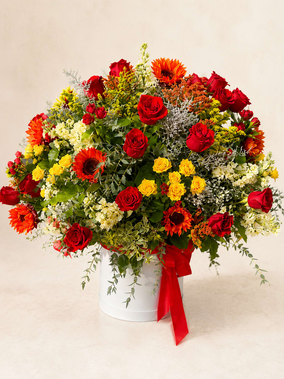 Sól's Golden Majesty – Grand Luxury Hat Box Arrangement - Inspired by Sól, the Norse goddess who guides the sun across the sky, this grand arrangement reflects warmth, brilliance, and unforgettable beauty.  One of Flower Fairy's signature luxury designs, this impressive hat box features premium red roses, vibrant sunflowers, spray roses, fragrant stock, seasonal flowers, and lush garden greenery. Designed in an airy garden style, its generous size, rich textures, and bold color palette create exceptional depth and visual impact, making it a true statement piece.  Perfect for milestone birthdays, grand anniversaries, luxury corporate gifts, grand openings, retirement celebrations, congratulations, or any occasion worthy of an extraordinary floral gift.  Each arrangement is handcrafted by Flower Fairy using the freshest flowers available. While occasional substitutions may be necessary due to seasonal availability, we always preserve the overall style, color palette, and premium quality of every design.  Features: Grand luxury hat box Premium red roses Sunflowers &amp; spray roses Seasonal flowers Garden-style design Keepsake hat box Same-day flower delivery in Phoenix