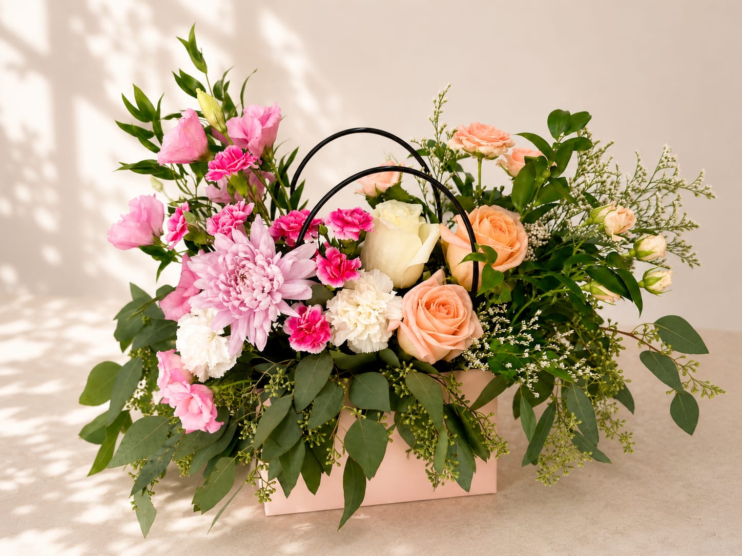 Nantosuelta's Whisper – Luxury Flower Bag Arrangement - Inspired by Nantosuelta, the Celtic goddess of nature, abundance, and the warmth of home, this elegant flower bag is a graceful expression of comfort, beauty, and heartfelt generosity.  Designed in Flower Fairy's signature garden style, this luxury flower bag features peach roses, white roses, chrysanthemums, carnations, lush greenery, and carefully selected seasonal flowers. The delicate palette of blush pink, peach, white, and fresh green creates a naturally balanced composition with graceful movement and a refined boutique feel. Presented in an elegant keepsake flower bag with modern handles, it makes a beautiful gift for any special occasion.  Perfect for birthdays, anniversaries, thank-you gifts, Mother's Day, baby showers, congratulations, get well wishes, or simply brightening someone's day.  Each arrangement is handcrafted by Flower Fairy using the freshest flowers available. While occasional substitutions may be necessary due to seasonal availability, we always preserve the overall style, color palette, and premium quality of every design.  Features: Luxury flower bag Premium roses Chrysanthemums Carnations Seasonal flowers Garden-style floral design Handcrafted by Flower Fairy Same-day flower delivery in Phoenix