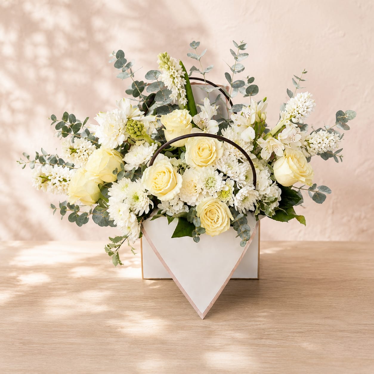 Rosmerta's Letter of Comfort - Rosmerta's Letter of Comfort is inspired by Rosmerta, the Celtic goddess of abundance, generosity, and protection. Revered as a symbol of compassion and blessings, she represents the comfort we offer one another in times of loss.  Premium ivory roses are complemented by fragrant white stock, fresh eucalyptus, and seasonal white blooms to create an airy, garden-inspired design. The soft white palette represents peace, purity, and everlasting love, making this arrangement a meaningful tribute for funeral services, memorials, celebrations of life, or to offer comfort to grieving family and friends.  Handcrafted with the freshest flowers available, each arrangement is uniquely designed with care and elegance, creating a beautiful keepsake presentation that reflects Flower Fairy's signature style. Whether sent to a funeral service, memorial, celebration of life, or directly to a loved one's home, Rosmerta's Letter of Comfort delivers a meaningful message that love is never forgotten.  Perfect For: Sympathy &amp; Condolences Funeral Services Memorial Services Celebration of Life Sending Comfort Thinking of You  Features: Premium ivory roses Fragrant white stock Fresh eucalyptus Seasonal white accent flowers Elegant envelope keepsake container Handcrafted by Flower Fairy designers Same-day local delivery throughout the Phoenix metro area