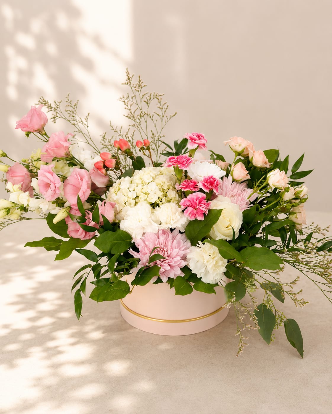 Mago's Bloom – Luxury Garden Hat Box -  Inspired by Mago, a figure from Basque mythology associated with magic and enchantment, this luxurious garden arrangement celebrates the wonder and beauty found in nature's most exquisite blooms.  Designed in Flower Fairy's signature garden style, this elegant hat box features lush white hydrangea, blush and white roses, soft pink lisianthus, carnations, chrysanthemums, seasonal flowers, and fresh greenery. Its airy silhouette and delicate palette of blush pink, ivory, and fresh green create a naturally flowing design that feels refined, modern, and timeless. Arranged in a blush keepsake hat box, it brings effortless elegance to any celebration.  Perfect for birthdays, Mother's Day, baby showers, anniversaries, thank-you gifts, congratulations, housewarmings, or simply letting someone know you're thinking of them.  Each arrangement is handcrafted by Flower Fairy using the freshest flowers available. While occasional substitutions may be necessary due to seasonal availability, we always preserve the overall style, color palette, and premium quality of every design.  Features: Luxury hat box arrangement White hydrangea Premium roses Carnations Seasonal flowers Garden-style floral design Handcrafted by Flower Fairy Same-day flower delivery in Phoenix