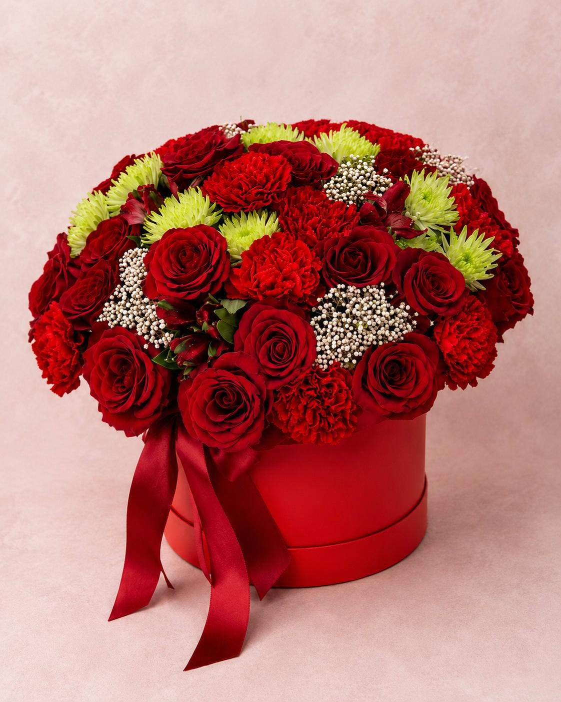 Erzulie's Velvet Aria – Luxury Hat Box - Inspired by Erzulie, the Haitian loa of love, beauty, luxury, and passion, this striking arrangement celebrates romance in its most elegant form.  Erzulie's Velvet Aria features luxurious red roses, rich red carnations, vibrant green spider chrysanthemums, delicate baby's breath, and seasonal accents, beautifully arranged in a premium hat box. The bold crimson palette and lush textures create a timeless expression of romance, passion, and heartfelt devotion.  Perfect for anniversaries, Valentine's Day, birthdays, romantic celebrations, or simply reminding someone how deeply they are loved.  Every arrangement is handcrafted by Flower Fairy using the freshest premium flowers available. Seasonal substitutions may occasionally be necessary while preserving the overall style, color palette, and value of the design.  Features: Premium red roses Red carnations Green spider chrysanthemums Baby's breath accents Seasonal floral accents Luxury hat box Handcrafted by Flower Fairy Same-day flower delivery throughout the Phoenix Metro Area