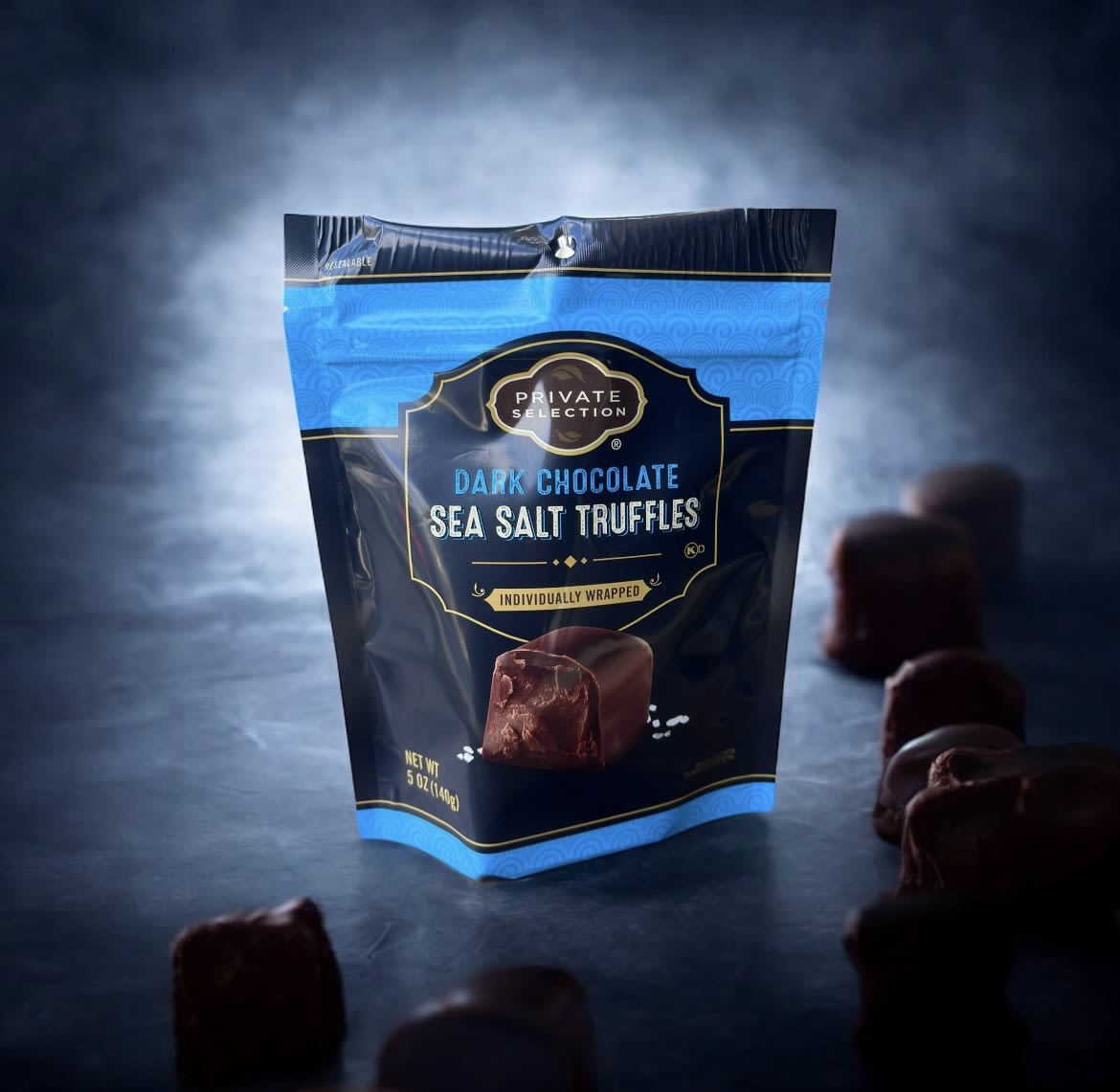 Bag of dark chocolate sea salt truffles with pieces scattered around
