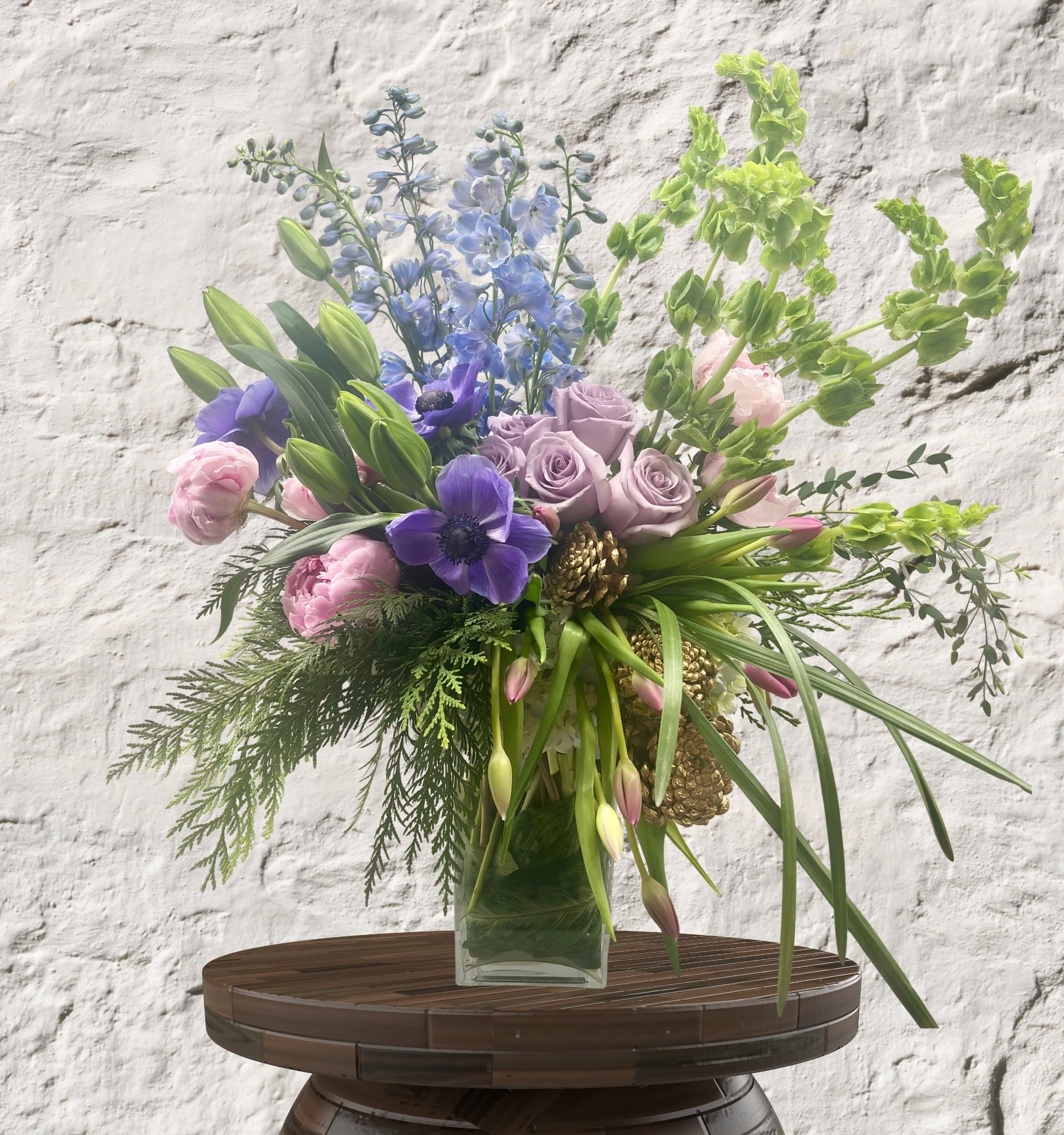 Bouquet of purple, pink, and blue flowers in a clear glass vase