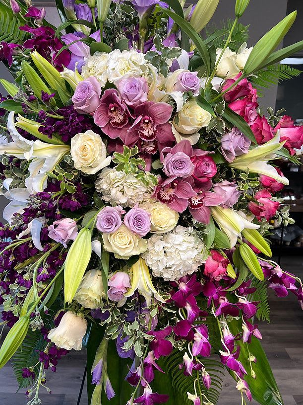 Large bouquet of roses, lilies, orchids, and hydrangeas in pink, purple, and white