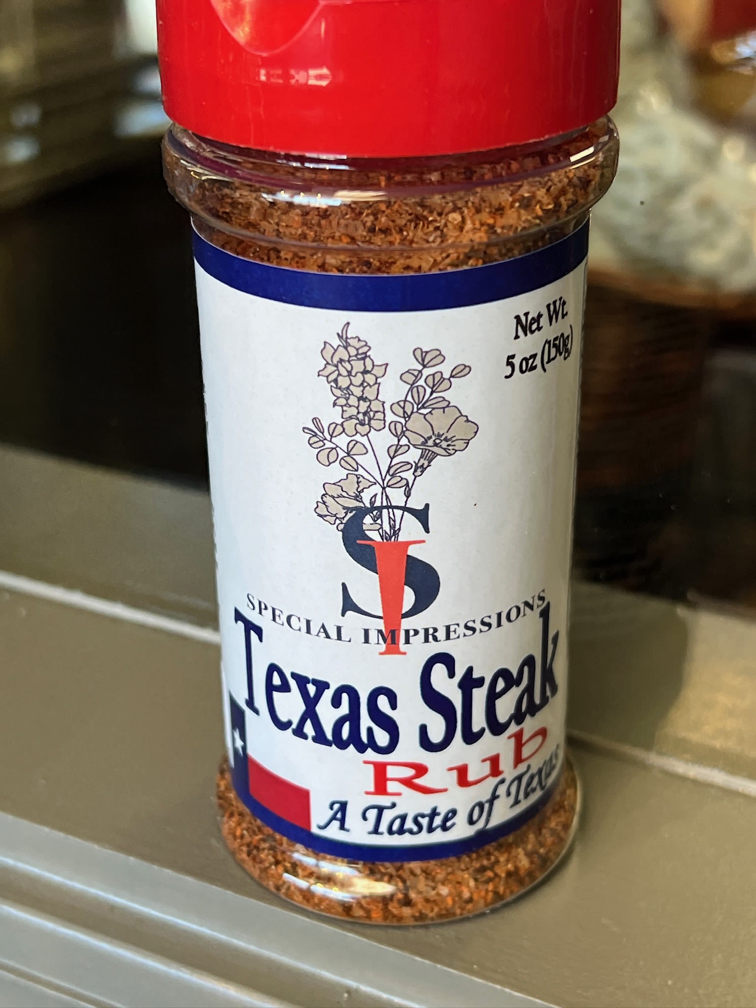Jar of Texas Steak Rub seasoning with a red lid