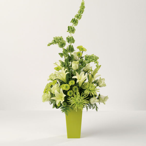 Green and white floral arrangement in a tall lime vase