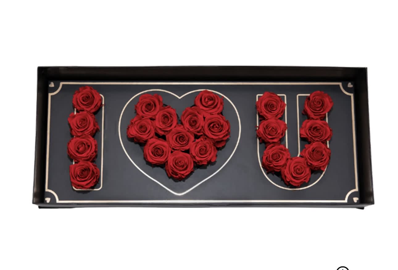 Red roses arranged to spell I heart U in a black box