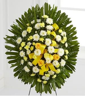 Round standing floral wreath with white and yellow flowers and yellow ribbon accents