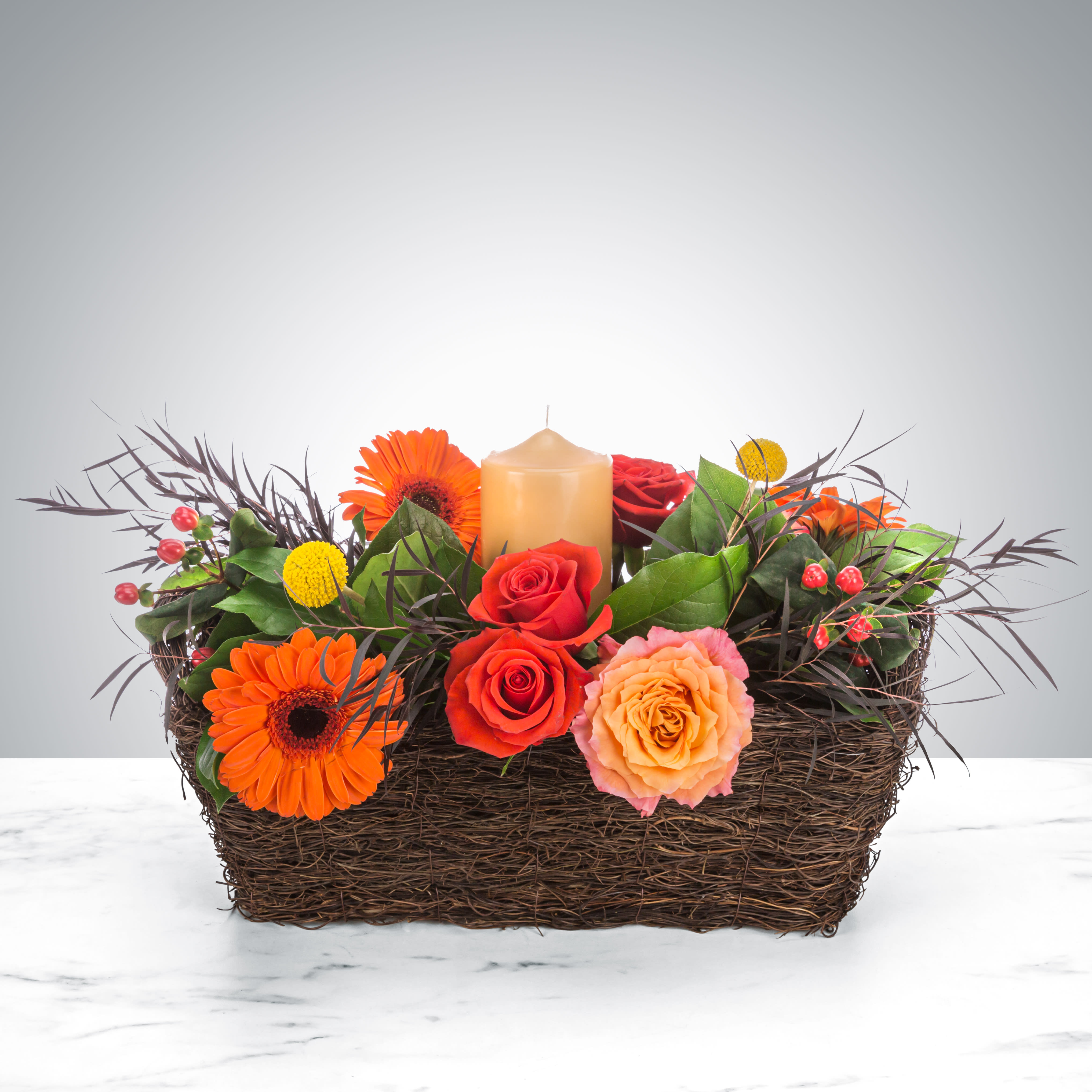 Harvest Equinox by BloomNation™ - A perfect autumn dinner party centerpiece, this arrangement features roses, daisies, and a center candle. Perfect for Thanksgiving, a Halloween dinner, or Rosh Hashanah.  Approximate Dimensions: 14"D x 10"H