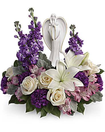 Purple and white floral arrangement with an angel figurine