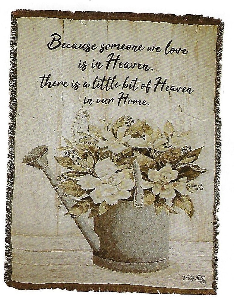 Decorative wall hanging with a watering can of white flowers and a memorial quote