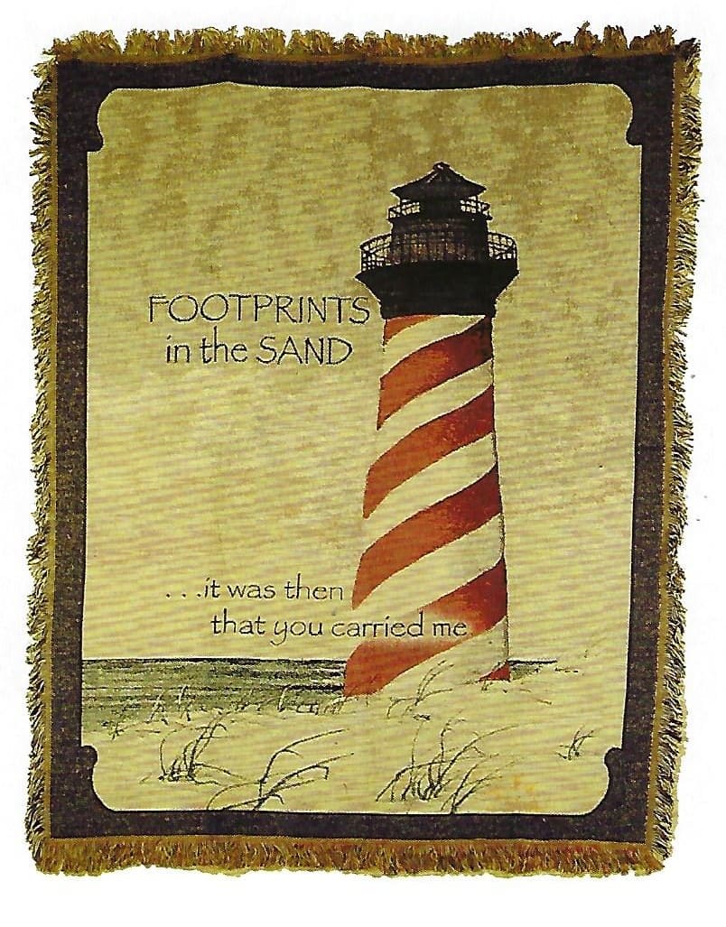 Decorative blanket with a lighthouse and the words "Footprints in the Sand"